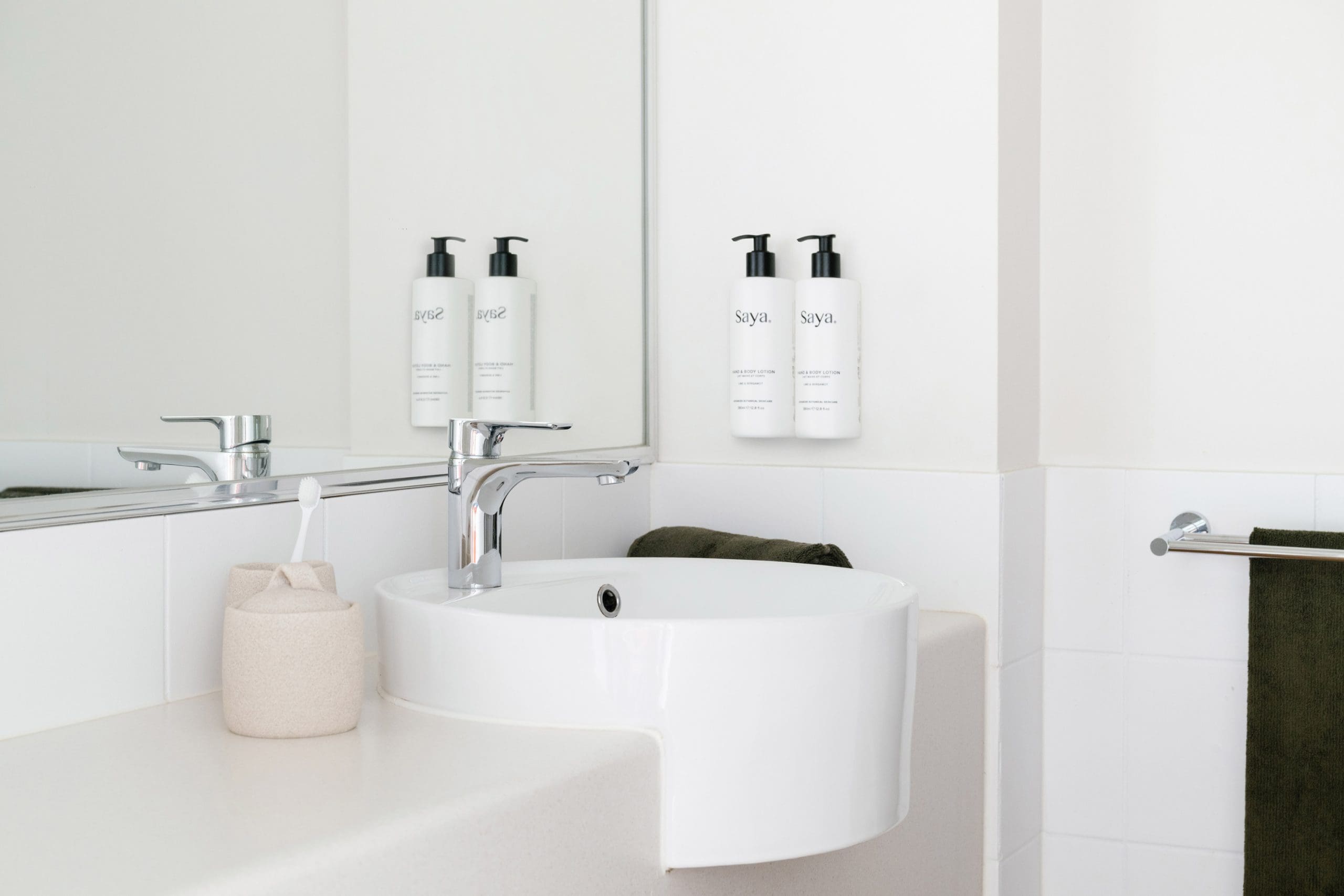 The Leea Darwin hotel bathroom sink with Saya toiletries and a toothbrush holder.